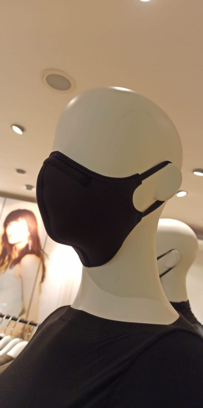 Eine weiße Schaufensterpuppe trägt eine scharze Atemschutzmaske